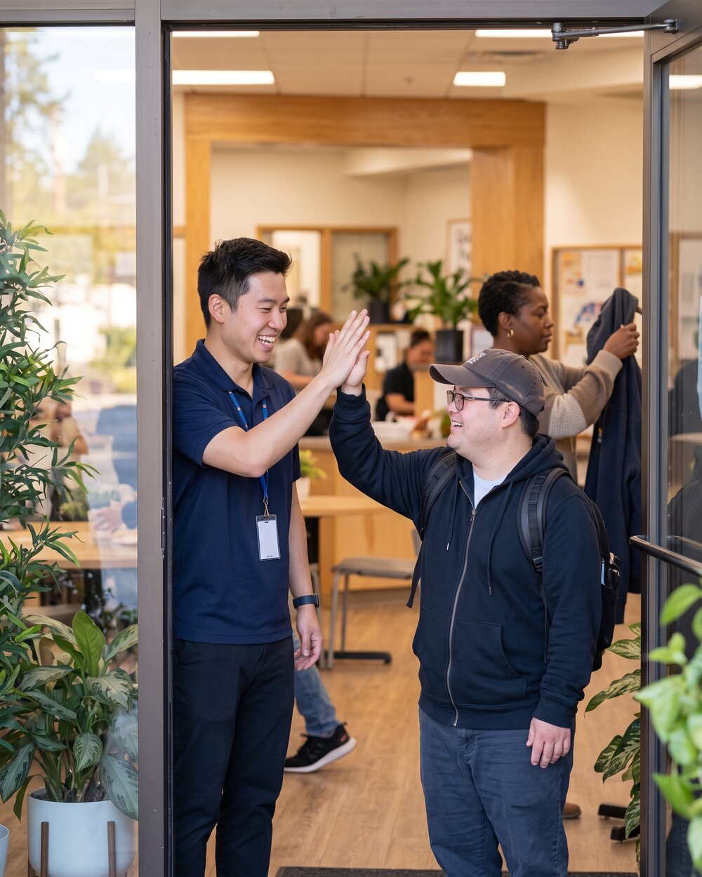 A staff member greets a participant at the door